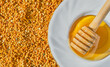 © Ed - Bee pollen in granules and honey in a saucer with a spindle spoon, top view of environmentally friendly food supplements and health improvement. Useful products, idea for background or advertising