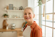 © Anatoliy Karlyuk - Indoor face portrait of good-looking attractive blonde lady grandmother with short hair posing against kitchen interior smiling, standing next to big window, dressed in cool stylish clothes