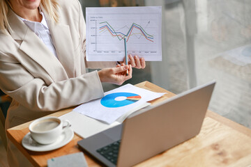 Wall Mural - Close up of businesswoman making online videoconference and demonstrate financial graphs 