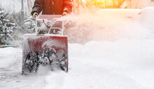 Snowblower Removes Snow, A Man Cleans The Yard Outside