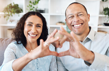 Wall Mural - Hand, heart and portrait of mature couple with love on sofa for bond, romance and happy in living room. Hands, emoji and face of older man with woman, happy or smile while enjoying retirement at home