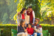 happy Indian family sitting at park in winter wear or warm clothes.
