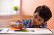 © IndiaPix - Portrait of a little boy drawing with colour pencil