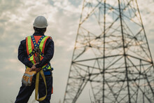 Asian Electrical Engineer Wearing Safety Gear Working High Voltage Pylon Engineering Work On High-voltage Pylons At Power Stations Using Drones To View Power Generation Planning From High-voltage Pylo