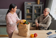 Social Worker Delivering Groceries To Senior Man