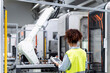 © Westend61 - Engineer controlling robotic arm with equipment in factory