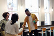 © Westend61 - Happy businessman greeting colleague at workplace