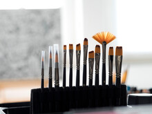 Variety Of Paintbrushes Arranged On Rack In Office