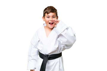 Wall Mural - Little caucasian kid doing karate over isolated chroma key background shouting with mouth wide open