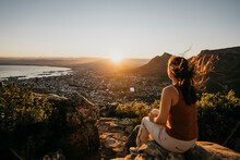 Woman On Rock Looking At Cityscape From Lion's Head Mountain At Sunrise