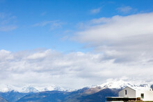 Art Museum Near Snowcapped Mountains Under Clouds On Sunny Day