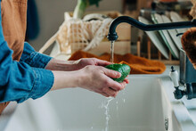 Hands Of Woman Washing Avocado In Kitchen Sink