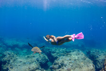Young Woman With Snorkel And Flippers Swimming Underwater At Sharks Cove, North Shore Of Oahu, Hawaii, USA