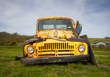 A Rusty Old Antique Yellow Work Truck On The Grass