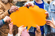 © william87 - Multicultural group of friends holding an empty orange thought bubble