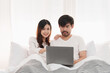 © itchaznong - Beautiful asian couple in love and smiling sitting on bed. Romantic moment, relationships, family concept.