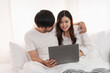 © itchaznong - Beautiful asian couple in love and smiling sitting on bed. Romantic moment, relationships, family concept.