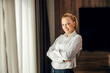 © Dusan Petkovic - A proud businesswoman is standing next to a window in her hotel room on her business trip.