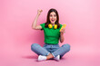 © deagreez - Full size portrait of delighted funky girl sit floor hold smart phone raise fist success isolated on pink color background