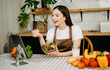 © Nuttapong punna - Young woman video blogger cooking at the kitchen and filming healthy food concept at home