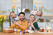 © New Africa - Portrait of happy family and Easter eggs at table in kitchen
