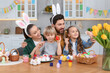 © New Africa - Happy family painting Easter eggs at table in kitchen