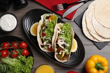 Wall Mural - Delicious fresh vegan tacos served on wooden table, flat lay