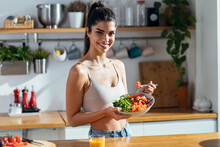 Fintess Woman Eating A Healthy Poke Bowl While Looking At Camera In The Kitchen At Home.