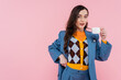© LIGHTFIELD STUDIOS - brunette woman in blue blazer holding cup of coffee isolated on pink.