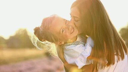 family day. young mom and little daughter enjoy relaxing in a field with lavender at sunset. a beaut