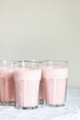 Glasses of strawberry milkshake or smoothie on table.
