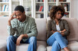 © Prostock-studio - Unhappy black couple sittng on sofa at therapist office