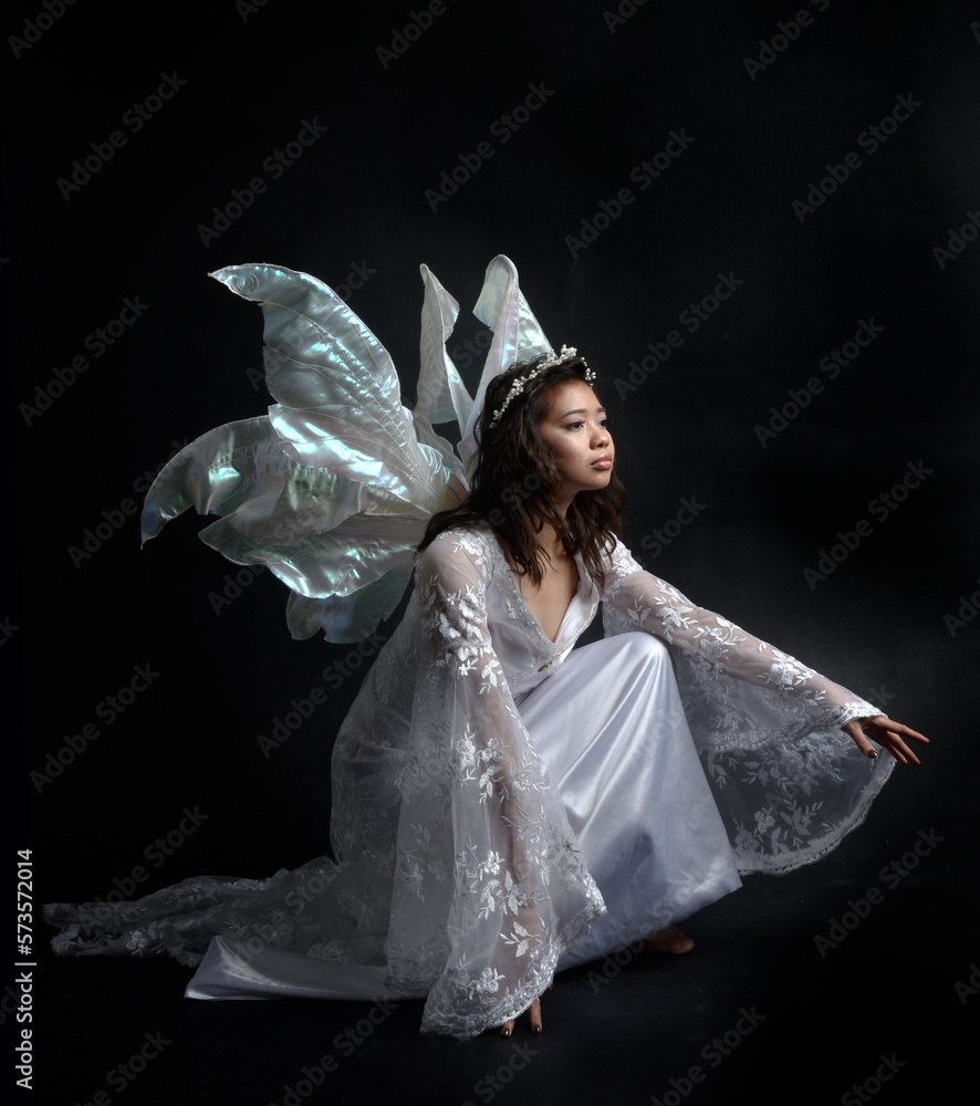 portrait of beautiful woman wearing fantasy costume with white bridal gown and translucent fairy wings. Posing with gestural arms reaching out, isolated on black studio background. Stock Photo | Adobe Stock portrait of beautiful woman wearing fantasy costume with white bridal gown and translucent fairy wings. Posing with gestural arms reaching out, isolated on black studio background. Stock Photo | Adobe Stock