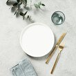 © Natalia Klenova - Minimal styled table setting with eucalyptus branches. Top view with copy space.