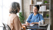 © amnaj - Asian female doctor examining a patient to assess the illness for proper treatment.