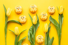 Set Of Easter Macaroon Chicks With Yellow Tulips Over Yellow Background. Top View, Flat Lay. Easter Background Or Greeting Card. Holiday Symbol