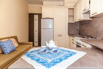 a small kitchen table in the apartment served with cutlery tea pairs for a joint breakfast for two