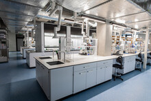 Chemistry Lab With White Cabinets, Chemist Workstations And Swivel Castor Chairs. High Room. Chemical Preparations, Test Tubes And Chemical Devices.