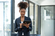 © crizzystudio - Smiling african american businesswoman holding tablet standing happy working in the financial field Banking in the office in the office business woman manager concept.