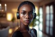© oleksandr.info - A young black woman is enjoying listening music in headphones at home.