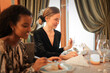 © olly - two young women eat in an elegant restaurant