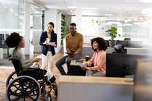 African American Businesswoman On Wheelchair And Diverse People In Office Talking And Laughing