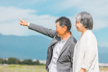 Poster - 公園・旅行先を話しながら歩く高齢者夫婦（シニア・男女）
