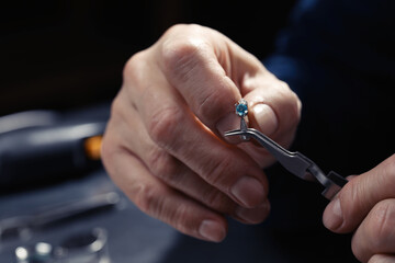 Wall Mural - Professional jeweler working with ring, closeup view