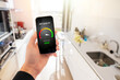 © Kaspars Grinvalds - Person in kitchen at home viewing air quality index on mobile phone
