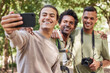 © T Mdlungu/peopleimages.com - Friends take selfie, hiking and outdoor in nature, men with phone, camera and happy trekking in woods. Social media, post and travel with fitness and group, smile in picture and trust on adventure