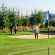 © ARochau - Golfer spielt einen Ball gekonnt aus dem Bunker auf das Grün