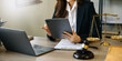 © Nuttapong punna - justice and law concept. asian woman lawyer working and judge in a courtroom the gavel, working with tablet and laptop and digital tablet computer