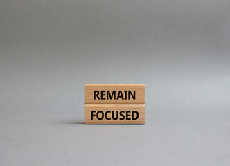 Remain focused symbol. Concept words Remain focused on wooden blocks. Beautiful grey background. Business and Remain focused concept. Copy space.