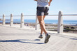 Fitness, sports and legs of man running by ocean for wellness, performance and athlete endurance. Nature, motivation and feet of male runner by sea for exercise, marathon training and cardio workout